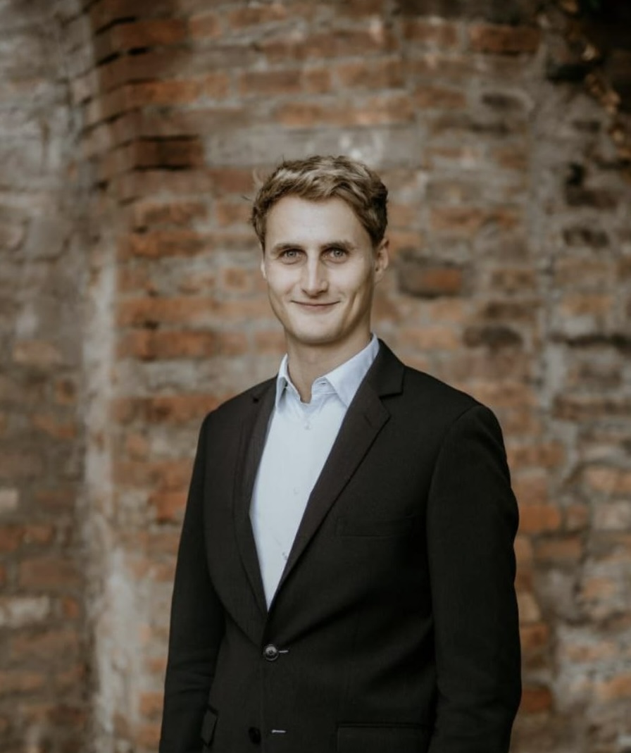 Merlin Wassermann poses in front of a brick wall