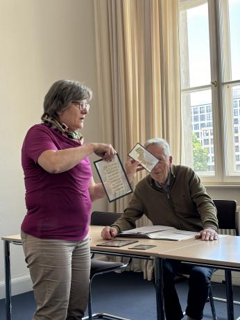 woman holding two manuscripts while presenting