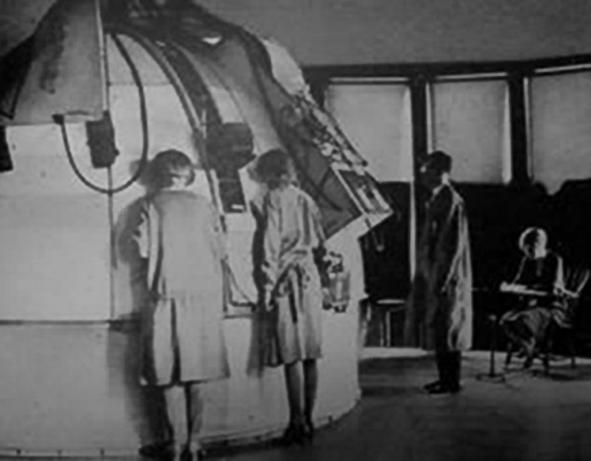 Three persons standin in front of Arnold Gesell’s Photographic Dome for studying normal babies.