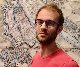 Ian Patrick Gray (red t-shirt) posing in front of a historical map