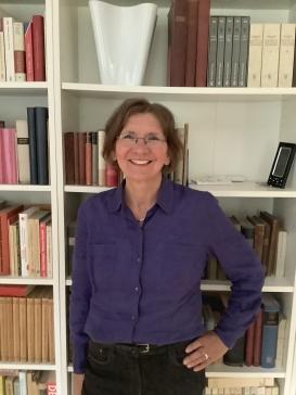 Ursula Klein posing in front of a book shelf